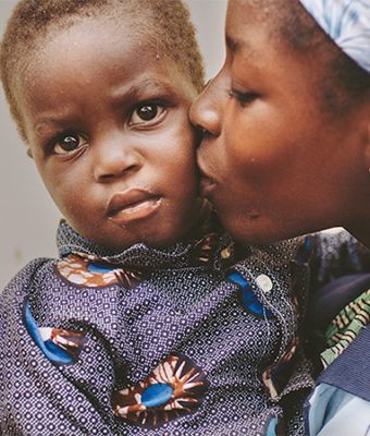 Een moeder kust haar kind.