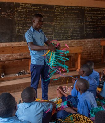 Een man geeft een presentatie voor een klas met kinderen.