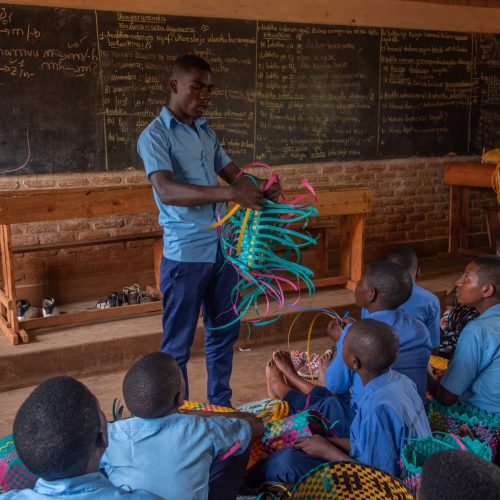 Een man geeft een presentatie voor een klas met kinderen.