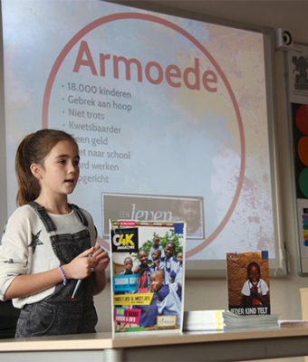 Een meisje houdt haar spreekbeurt over armoede.