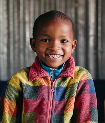 Keniaanse jongen met geblokt vest.