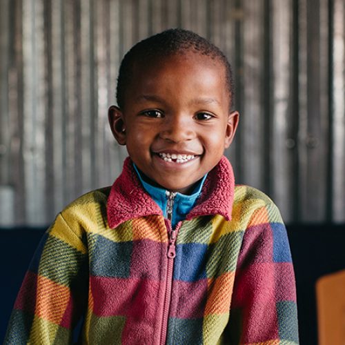 Keniaanse jongen met geblokt vest.