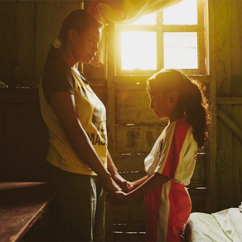 Een vrouw en haar dochter bidden samen.