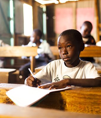 Een jongen uit een Compassion-project zit in de klas in Kenia.