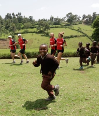 Kinderen en muskathleten rennen in Tanzania.