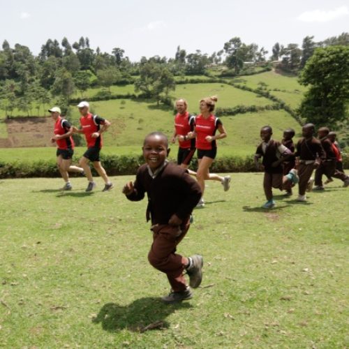 Kinderen en muskathleten rennen in Tanzania.