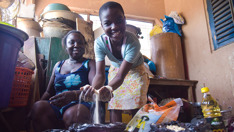 Meisje heeft meel in haar handen en lacht.