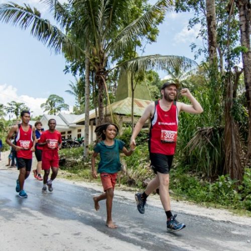 Man rent samen met meisje over de weg.